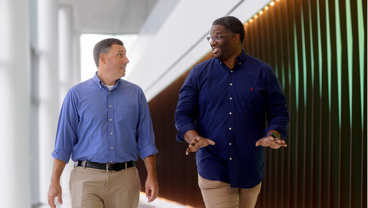 Two people walking down a hallway